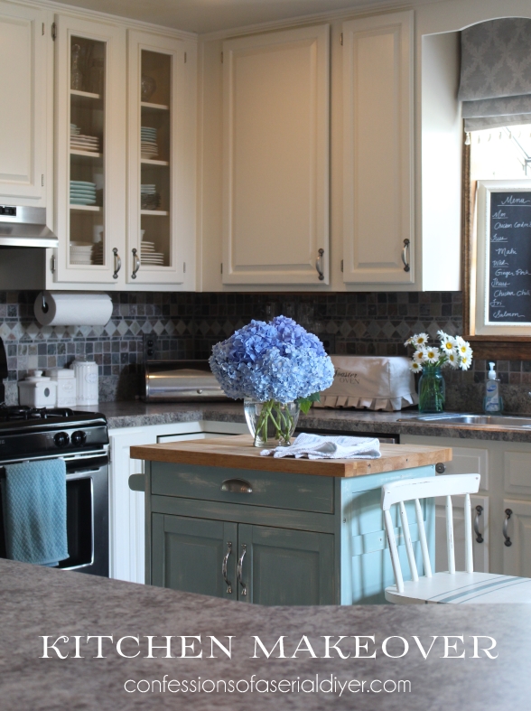 The kitchen with a light blue small island and flowers on the island.