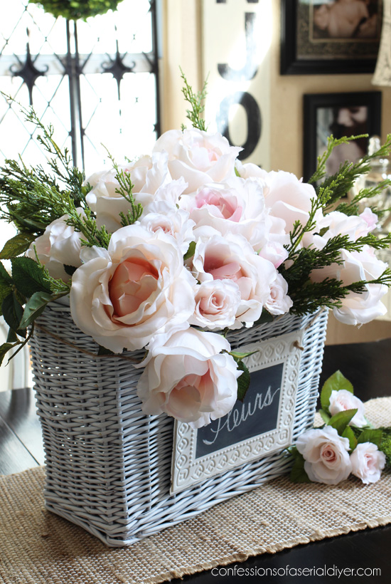 Faux camellias and miniature roses make the perfect Spring centerpiece in this basket. confessionsofaserialdiyer.com