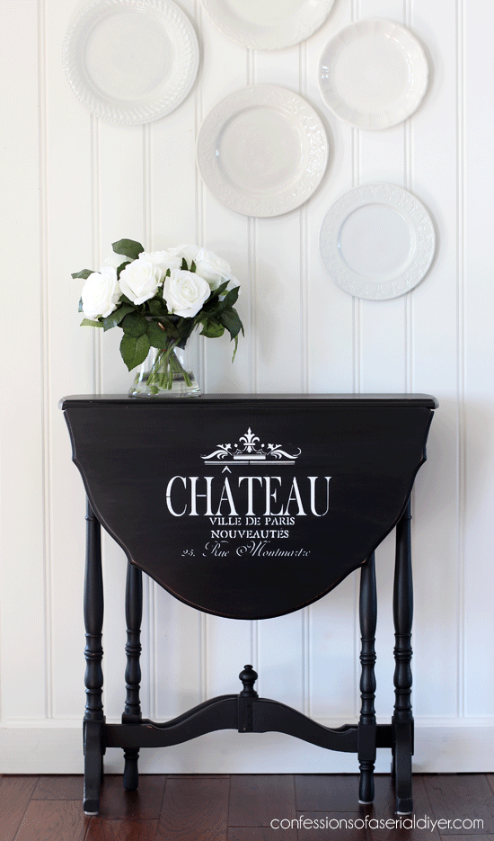 Drop leaf side table painted black with the addition of graphics. 