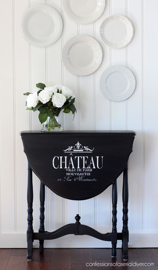 Drop leaf side table painted black with the addition of graphics.