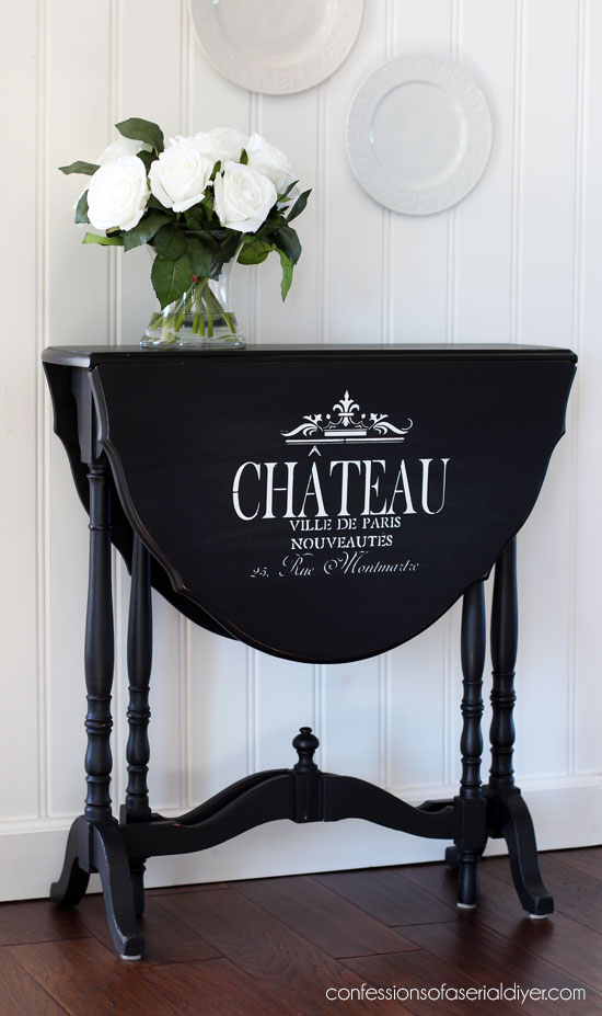 Drop leaf side table painted black with the addition of graphics. 