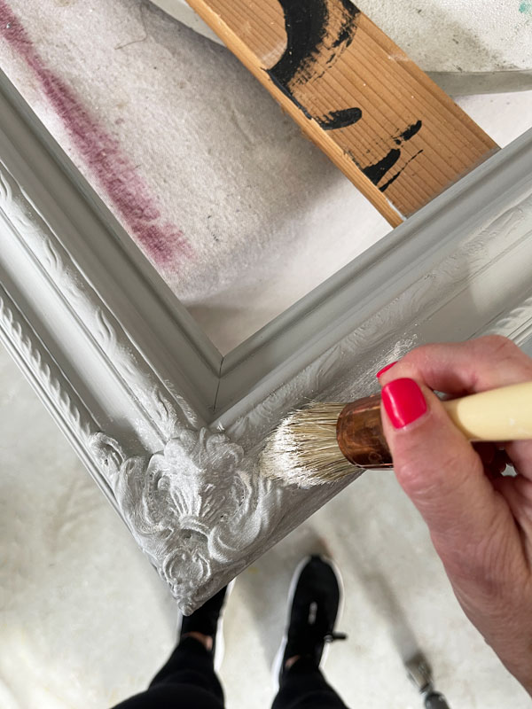 Applying white wax to a mirror frame