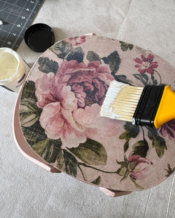 Adding decoupage paper to the top of a basket lid.